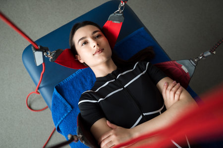 Red Cord supervised therapies to activate muscles. Girl is getting ready for red cord physiotherapy...