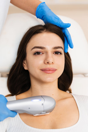 Attractive girl is having facelift procedure in cosmetology clinic. Ultraformer nonsurgical facelift processの写真素材