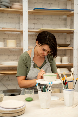 Painting ceramic products using acrylic paint and brush. Making a colorful decoration of a clay...