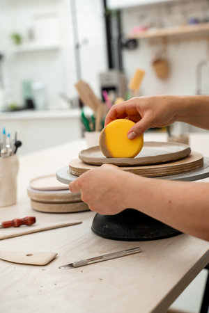 Using sponge for pottery class. Absorbing sponge to get rid of excess moisture. Applying more moisture on clay products. Smoothing clay with a sponge. Ceramics workshopの写真素材