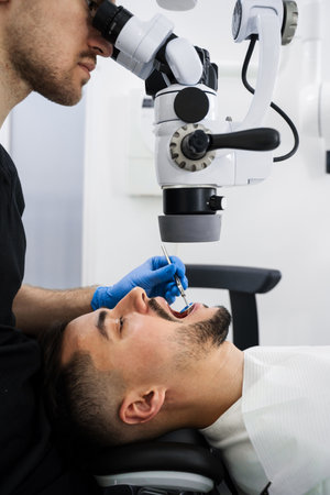 Operating dental digital microscope working process. Dentist uses operating microscope to polish...