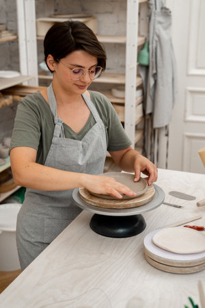 Creating ceramic products from flat sheets of clay. Using hands to model a form for a clay project....