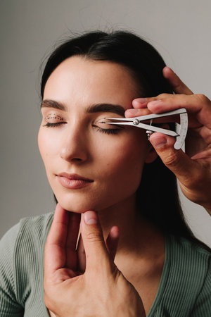 Castroviejo caliper to draw symmetrical contour for eyelid surgery. Blepharoplasty marking up. Plastic surgeon is measuring distance in between marking lines for well planned blepharoplastyの写真素材