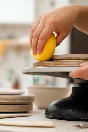 Using sponge for pottery class. Absorbing sponge to get rid of excess moisture. Applying more moisture on clay products. Smoothing clay with a sponge. Ceramics workshopの写真素材
