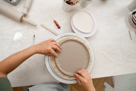 Creating ceramic products from flat sheets of clay. Using hands to model a form for a clay project....