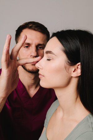 Rhinoplasty to improve appearance of nose. Woman is going through rhinoplasty nose surgery to constantly remove dorsal humpの写真素材