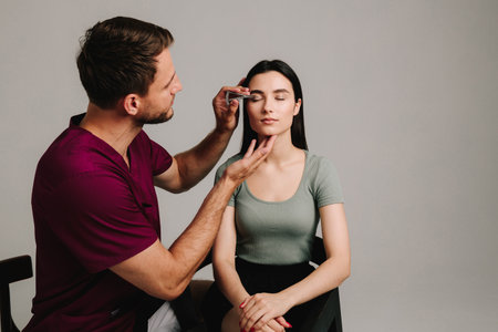 Castroviejo caliper to draw symmetrical contour for eyelid surgery. Blepharoplasty marking up. Plastic surgeon is measuring distance in between marking lines for well planned blepharoplastyの写真素材