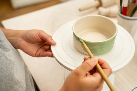 Painting ceramic products using acrylic paint and brush. Making a colorful decoration of a clay...