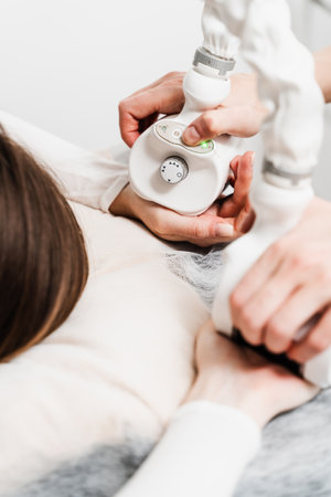 Targeting lymphatic system with rhythmic movements and massage to get rid of waste and toxins. Young woman is having lymphatic drainage treatment to remove leg swellingの写真素材