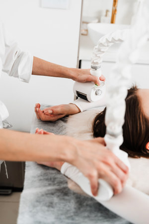 Targeting lymphatic system with rhythmic movements and massage to get rid of waste and toxins. Young woman is having lymphatic drainage treatment to remove leg swellingの写真素材