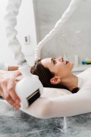 Targeting lymphatic system with rhythmic movements and massage to get rid of waste and toxins. Young woman is having lymphatic drainage treatment to remove leg swellingの写真素材