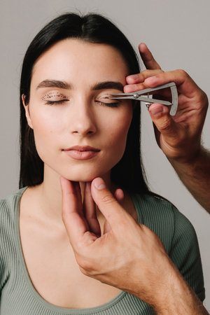 Plastic surgeon is measuring distance in between marking lines for well planned blepharoplasty. Using Castroviejo caliper to draw symmetrical contour for eyelid surgeryの写真素材