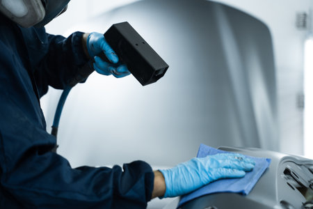 Mechanic is working with anti static gun to neutralize static electricity and remove dust before painting surface. Preparing car for painting with anti static gunの写真素材