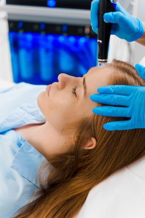 HydraFacial purifying procedure with medical device in beauty center. Beautician doing facial...