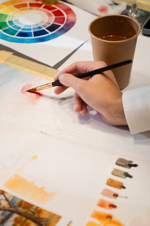 Drawing swatches with paint brush on the paper. Art process of mixing colors on the palette before painting in the art studioの写真素材