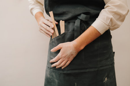 Artisan black apron holds different potters tools. Set of different potters instrumentsの写真素材