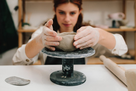 Process of creating ceramic products. Female potter hands shows ceramic bowl ready for firing in a kilnの写真素材
