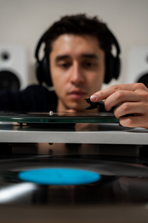 Music lover puts a vinyl record on needle player before listening retro music. LP record playing on...
