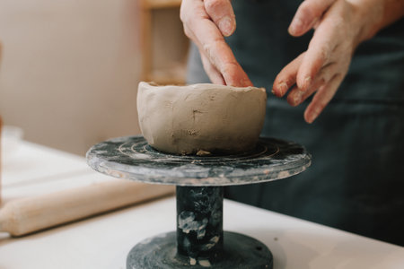 Process of creating ceramic products. Female potter hands shows ceramic bowl ready for firing in a kilnの写真素材