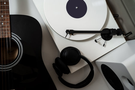 Vinyl turntable with white disk and speaker system with guitar and headphones. Set for music lover. Listen to music with Hi-Fi soundの写真素材