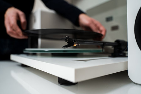 Musician hands are placing vinyl record on a turntable player. Music lover is under preparation vinyl player for playbackの写真素材