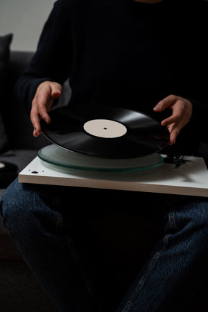 Inserting vinyl cartridge into needle at home. Musician puts on a vinyl record to play into turntableの写真素材