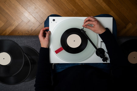 Person is playing a vinyl record on a turntable with a stereo sound.