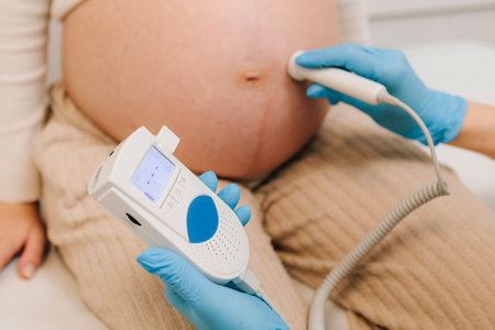 Gynecologist checks heart rate of pregnant woman on the appointment. Gynecologist listens to fetus...