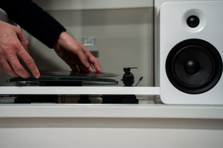 Musician hands are placing vinyl record on a turntable player. Music lover is under preparation vinyl player for playbackの写真素材