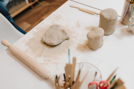 Hands of a female potter making ceramic clay product on the table in the pottery workshop. Potter is sculpting wet clay for ceramics productsの写真素材
