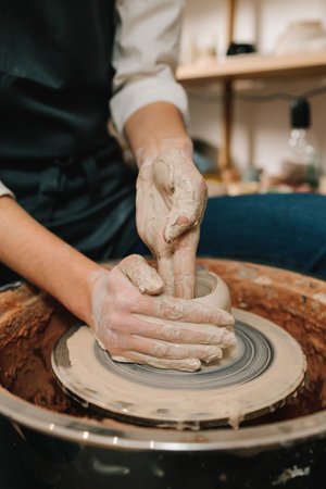Process of sculpting ceramic crockery in the manufacturing. Female potter forms a clay product on a...