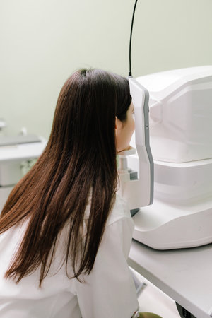 Optical coherence tomography OCT scan to create pictures of the back of eye. Examination of eyes of patient using optical coherence tomograph. Ophthalmologist is scanning cornea of girl patientの写真素材
