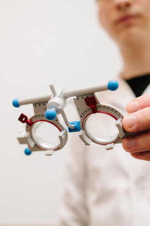 Trial glasses frame eye visual system of people with short or long power vision. Ophthalmologist holds trial frame glasses in hands in ophthalmology clinicの写真素材