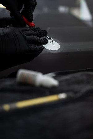 Professional windshield chip repair close-up during resin injection for damaged auto glass clarity. Precision windshield crack repair in progress with specialized toolsの写真素材