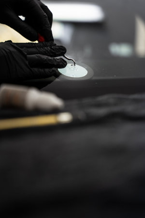 Professional windshield chip repair close-up during resin injection for damaged auto glass clarity. Precision windshield crack repair in progress with specialized toolsの写真素材
