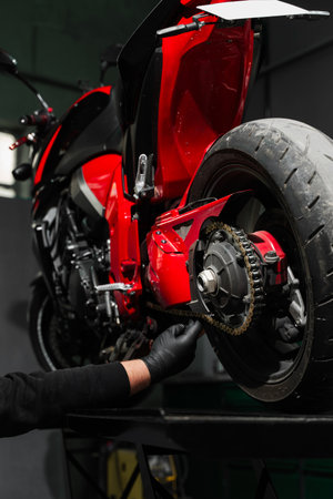 Chain tuning improves torque delivery and rear performance. Chain tensioning at motorcycle maintenance service. Motorcycle chain maintenance is essential for smooth riding and drivetrain longevityの写真素材