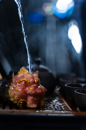 The Gongfu tea ritual features clay teacups, a teapot, and an ornate tea pet. Gongfu tea ceremony with clay cups and a detailed tea tray captured in warm lightingの写真素材