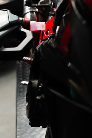 Precision oil fill operation on a red sportbike to ensure proper engine lubrication. Motorcycle Oil...