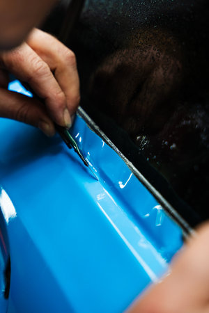 Sharp blade is used to finalize the detailing process, cutting PPF wrap with exact precision. PPF Trimming with Precision Knife. Knife trimming in vinyl wrap detailing is crucial for perfectionの写真素材