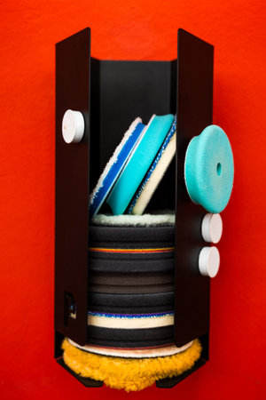 Detailing pads sorted by texture and purpose. Polishing pads arranged in holder. Auto detailing foam and microfiber pads. Organized polishing pads stored verticallyの写真素材