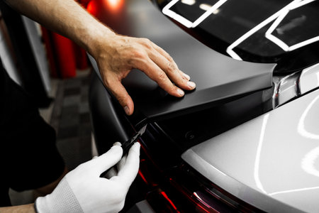 Manual vinyl cutting for perfect fitment and clean visual results. Vinyl Application in Progress in detailing. Vinyl film is trimmed with sharp blade to ensure seamless edges without gaps or tearsの写真素材