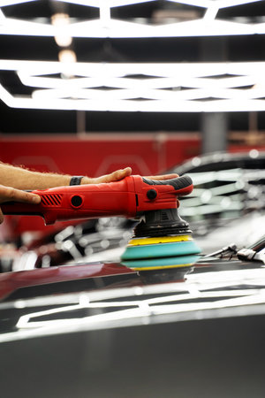Polishing revives vehicle paint with deep gloss and smoothness. Car paint correction and polishing. Polishing machine expertly removes paint swirls and oxidation for a flawless surfaceの写真素材