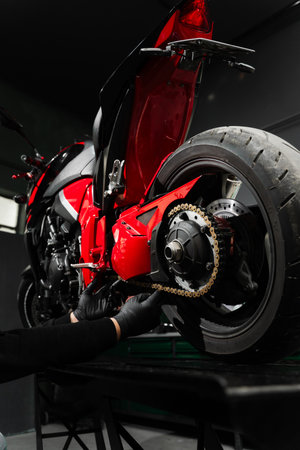Chain tuning improves torque delivery and rear performance. Chain tensioning at motorcycle maintenance service. Motorcycle chain maintenance is essential for smooth riding and drivetrain longevityの写真素材