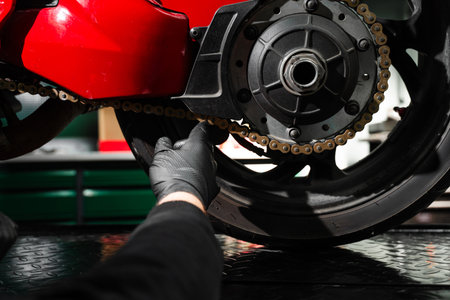 Motorcycle chain maintenance is essential for smooth riding and drivetrain longevity. Chain tuning improves torque delivery and rear performance. Chain tensioning at motorcycle maintenance serviceの写真素材