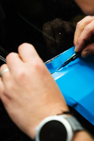 Sharp blade is used to finalize the detailing process, cutting PPF wrap with exact precision. PPF Trimming with Precision Knife. Knife trimming in vinyl wrap detailing is crucial for perfectionの写真素材