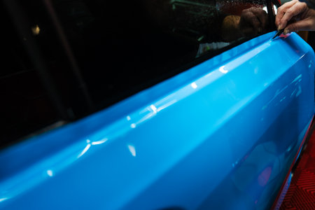 Sharp blade is used to finalize the detailing process, cutting PPF wrap with exact precision. PPF Trimming with Precision Knife. Knife trimming in vinyl wrap detailing is crucial for perfectionの写真素材