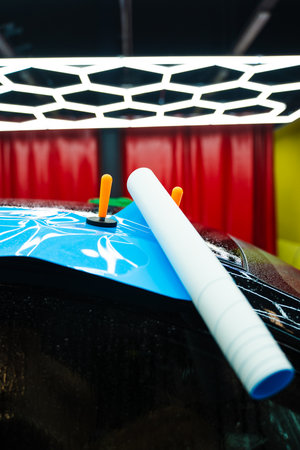 The wet application of Paint protection film prevents air bubbles and allows adjustment for a perfect fit. Wet PPF Application in Progress in Detailing centerの写真素材