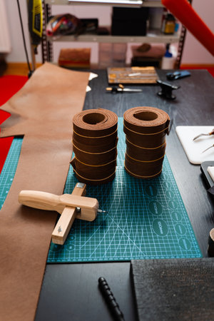 Leather rolls and strap cutter lie on cutting mat, ready for trimming strong belts and leather...
