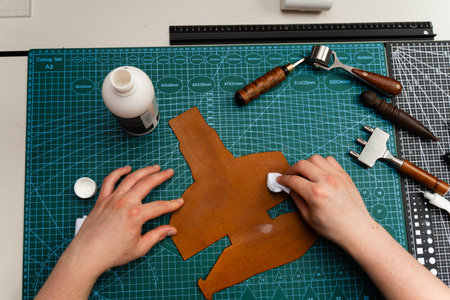 Applying conditioner or dye to leather with a cloth. Conditioning leather with a cloth restores shine, flexibility, and strength. Leather dye or conditioner application protects surface and colorの写真素材