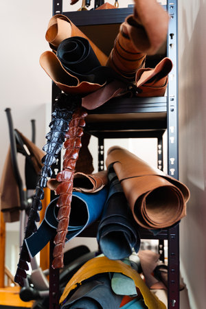 Leather rolls in multiple tones fill the shelves, offering a range of textures and finishes suited...